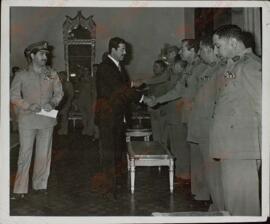 Sadam Hussein (1937-2006), saludando a un grupo de oficiales iraquíes, c. 1985.