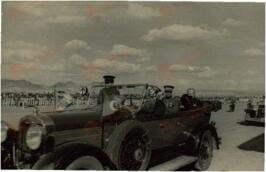 Fotografía impresa en papel postal de Mustafá Kemal, "Atatürk" (1881-1938) sentado en su automovil descapotable y saludando con su sombrero de copa en mano, c. 1930.